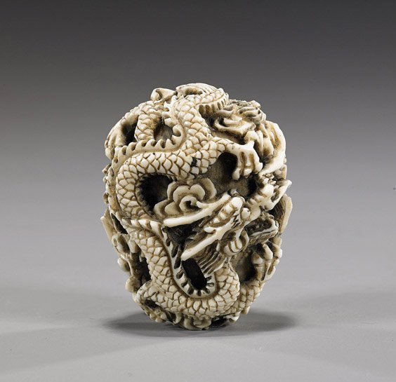 Carved Ivory Netsuke: Dragon & Phoenix: Carved Ivory Netsuke: Dragon & Phoenix Early 20th Century carved ivory netsuke; of oval form and with relief carved writhing dragon and phoenix among clouds contesting a pearl