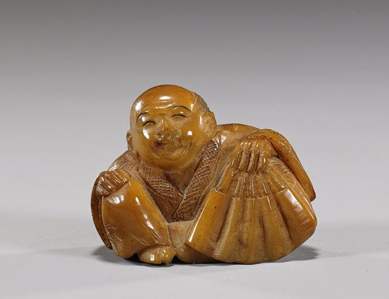Old Elephant or Vegetable Ivory Figural Netsuke: Old Elephant or Vegetable Ivory Figural NetsukeEarly 20th Century, carved elephant ivory or vegetable ivory (ginkgo nut) netsuke; of a seated man in long robes and holding a fan