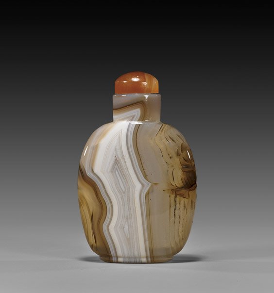 CARVED BANDED AGATE SNUFF BOTTLE: CARVED BANDED AGATE SNUFF BOTTLE Very finely hollowed, carved agate snuff bottle; of somewhat wide ovoid form, showing very attractive translucent banding in white and tan; carnelian agate stopper; H:
