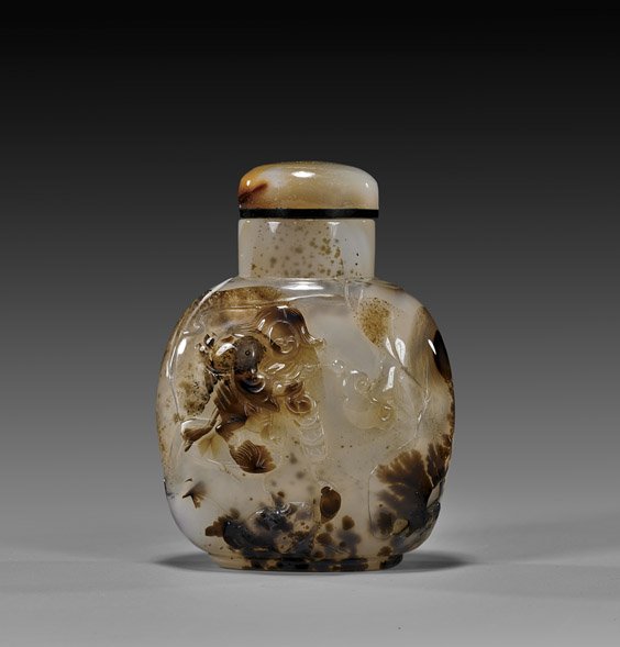 CARVED CAMEO AGATE SNUFF BOTTLE: CARVED CAMEO AGATE SNUFF BOTTLE Finely hollowed, large carved cameo/shadow agate snuff bottle: the front with relief design of Liu Hai holding a string of coins, with his three leg toad, in a rockery 