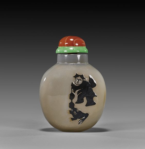 CARVED SHADOW AGATE SNUFF BOTTLE: CARVED SHADOW AGATE SNUFF BOTTLEFinely hollowed, shadow agate snuff bottle; the rounded form with figural design of Liu Hai with his three legged toad in black, on gray chalcedony background; carnelia