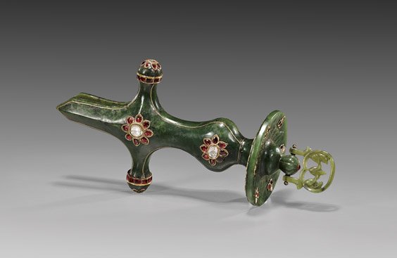 RARE MOGHUL SPINACH JADE SWORD HANDLE: RARE MOGHUL SPINACH JADE SWORD HANDLE Rare Moghul carved spinach jade sword handle: in cross form with foliate round base, and terminating with a hinged ornament; of Islamic design and set with typica