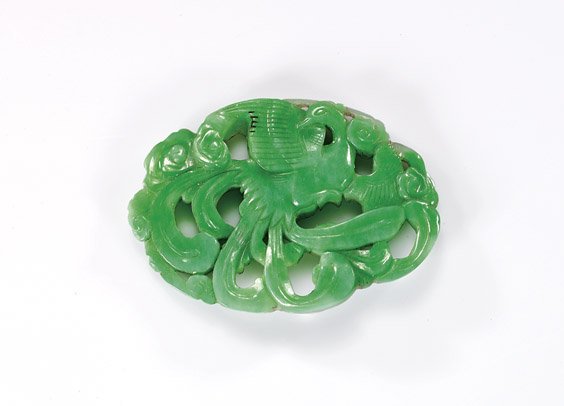 CHINESE CARVED GREEN JADEITE PENDANT: CHINESE CARVED GREEN JADEITE PENDANTEarly 20th Century, Chinese openwork jadeite pendant; of ovoid form, with beautifully carved design of a phoenix with scrolling feathers amid clouds: the front of b