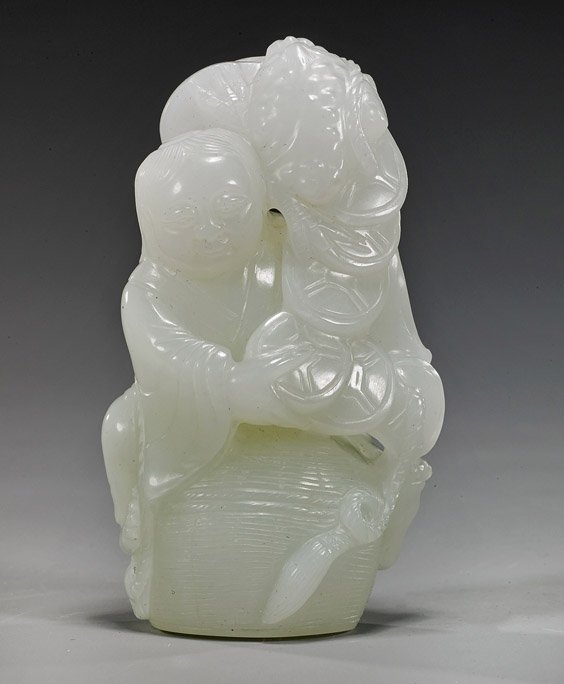 Chinese Carved Celadon Jade He-He Twins: Chinese Carved Celadon Jade He-He Twins Chinese carved whitish celadon jade group; depicting one of the He-he twins sitting on a basket and holding a string of cash, a three-legged toad at his shoulde