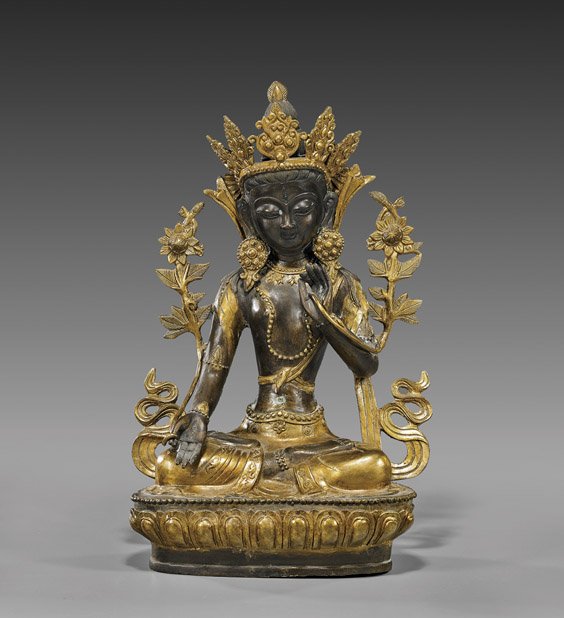 Nepalese or Tibetan Bronze Buddhist Deity: Nepalese or Tibetan Bronze Buddhist Deity Nepalese or Tibetan, parcel-gilt bronze Buddhist deity; seated atop a stylized lotus pedestal: in lotus posture and wearing elaborate jewelry and an openwork 