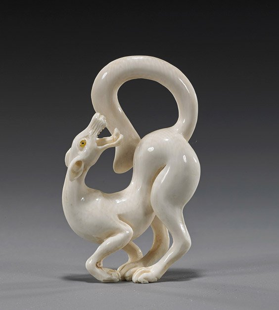 Carved Ivory Netsuke: Hound or Wolf: Carved Ivory Netsuke: Hound or Wolf Very well carved ivory netsuke; of a hound or wolf, standing in a twisted stance, with long tail and mouth open baring its teeth, inlaid eyes