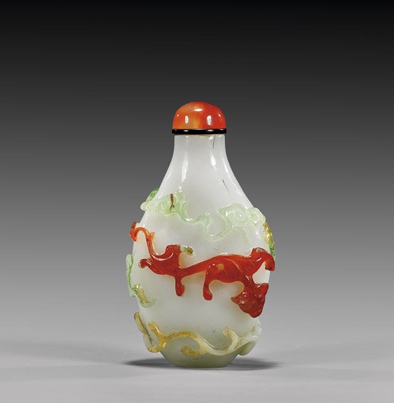 FOUR-COLOR OVERLAY GLASS SNUFF BOTTLE: FOUR-COLOR OVERLAY GLASS SNUFF BOTTLE Four-color overlay glass snuff bottle; of sloped ovoid form, with design of hydra and clouds in relief, on a milk-white ground; with carnelian agate stopper; earl