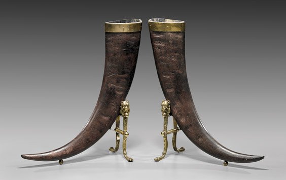 PAIR ANTIQUE WATER BUFFALO HORN VASES: PAIR ANTIQUE WATER BUFFALO HORN VASES Pair of antique, brass mounted water buffalo horn vases; each displaying fine patina; H: 27" (each approx., along the outer curve); lion motif brass stands ૒