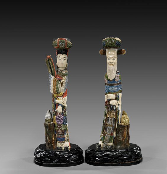 PAIR ANTIQUE JAPANESE IVORY FIGURES: PAIR ANTIQUE JAPANESE IVORY FIGURESPair of antique Japanese, elaborately carved and polychromed sectional ivory figures, each standing beside tree trunk, in decorative floral robes and bulbous headdre