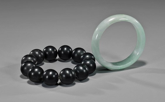 Two Chinese Bracelets: Wood & Jadeite: Two Chinese Bracelets: Wood & Jadeite Two Chinese bracelets: one comprised of large round exotic dark wood beads; together with a jadeite bangle of translucent pale green color; D: 3 1/2" (larger)