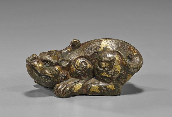 Unusual Chinese Archaistic Bronze Lion: Unusual Chinese Archaistic Bronze Lion Unusual Chinese Warring States-style bronze model; of a recumbent animal, decorated with archaistic gilt and silvered inlays (typical applied wear); L: 5"
