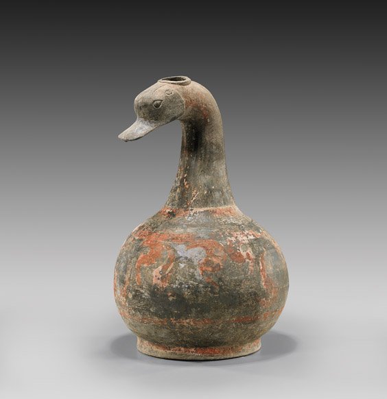 HAN DYNASTY POTTERY DUCK HEADED VESSEL: 陶加彩鵝形瓶 HAN DYNASTY POTTERY DUCK HEADED VESSEL Chinese Han Dynasty painted pottery vessel; formed with a well modeled duck head atop a bulbous body, painted wi