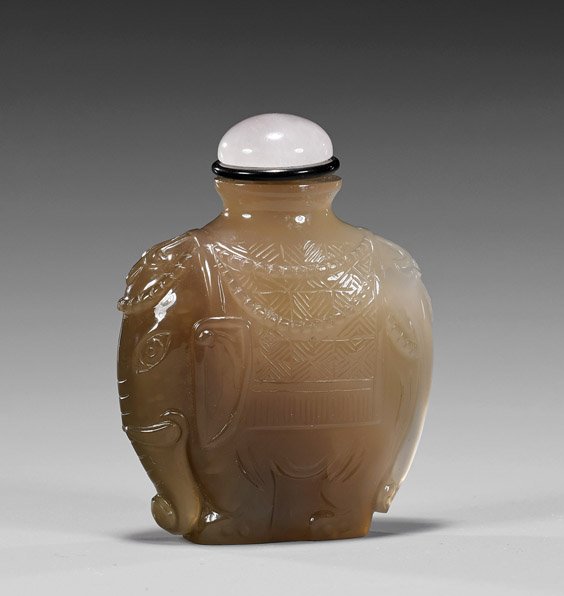 Grey Chalcedony Agate Snuff Bottle: Elephant: Grey Chalcedony Agate Snuff Bottle: ElephantCarved translucent grey chalcedony agate snuff bottle; of flattened form and rendered as a fancy caparisoned elephant, rose quartz stopper (usual minor wear