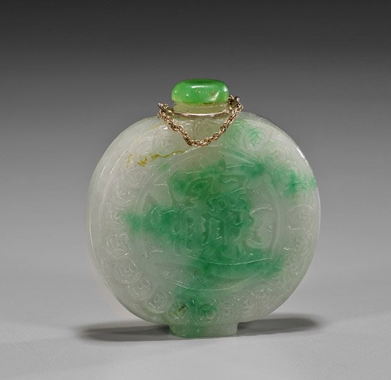 Carved Apple Green Jade Snuff Bottle: Carved Apple Green Jade Snuff BottleCarved jade snuff bottle; of flattened circular form, with a ring of coins and character motif to each side, of apple green suffusions, glass stopper (no spoon, pos