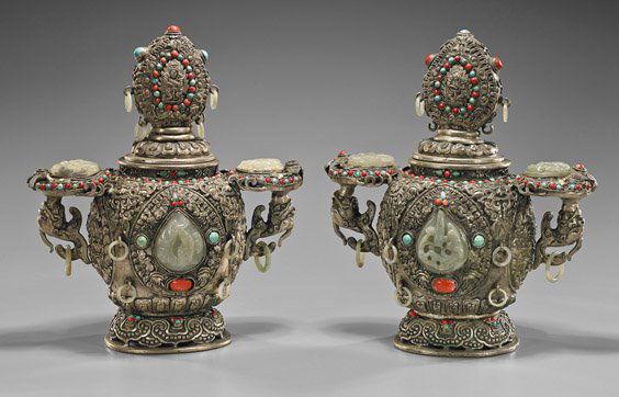 Pair Tibetan Repoussé Covered Urns: Pair Tibetan Repoussé Covered UrnsPair Tibetan silver or silvered covered urns; each of rounded form with flared foot: pending 14 loose jade rings, a carved jade chilong plaque to each side and handl
