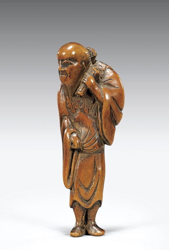 18TH CENTURY CARVED WOOD NETSUKE: Sennin: 木彫根付 18TH CENTURY CARVED WOOD NETSUKE: Sennin Antique carved wood netsuke; of a Sennin, standing in draped robes with a typical foliage wrap and holding a scroll, 18th Cent