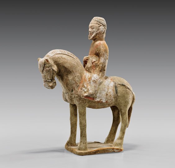 HAN DYNASTY POTTERY HORSE & RIDER: 陶騎馬俑 HAN DYNASTY POTTERY HORSE & RIDER Chinese Han Dynasty pottery horse and rider; of a bearded foreigner seated atop a horse with bowed head and simply painted trappings,