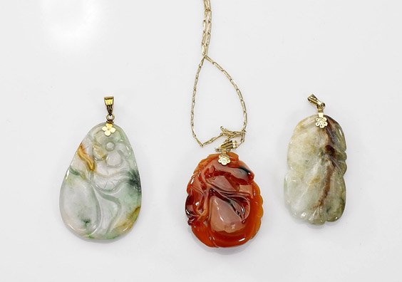 Three Chinese Carved Jade/Agate Pendants: Three Chinese Carved Jade/Agate Pendants Group of three Chinese carved jade and agate pendants, including: teardrop form with floral design to front and back, of russet and spinach green suffusions; o