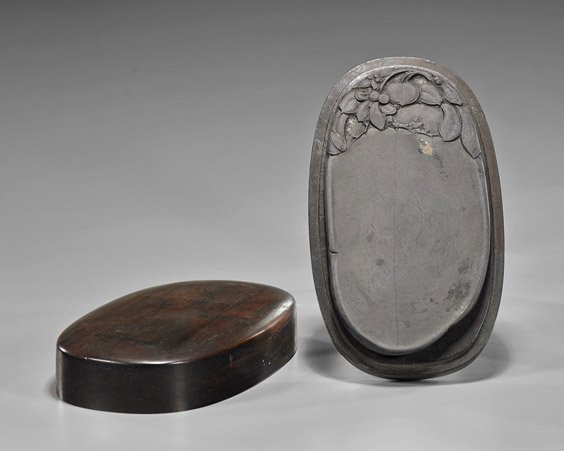 Chinese Carved Oval Inkstone: Chinese Carved Oval Inkstone Chinese carved inkstone; of oval form, decorated with peach and gourds hanging from fruiting branches, set in a wood box of finely grain (usual minor wear); W: 7"