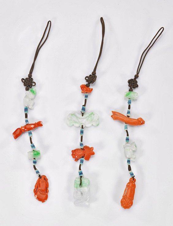 Three Chinese Carved Jadeite & Coral Toggles: Three Chinese Carved Jadeite & Coral Toggles Set of three Chinese carved jadeite and coral hanging toggles: all on brown silk cord depicting various Buddhist emblems; L: 4" (each)