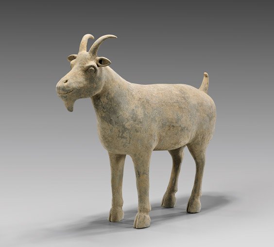HAN DYNASTY POTTERY GOAT: 陶羊俑 HAN DYNASTY POTTERY GOAT Chinese Han Dynasty gray pottery model; of a large well-potted goat with horns and an upturned tail, standing on all fours; L: 15 1/2"; with Oxford TL
