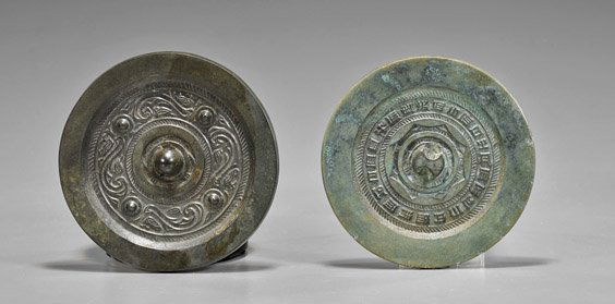 Two Early Chinese Bronze Mirrors: Two Early Chinese Bronze MirrorsTwo early Tang/Song Dynasty Chinese bronze mirrors; each circular and well cast with center band of designs: abstract animal designs with four bosses; together with mul