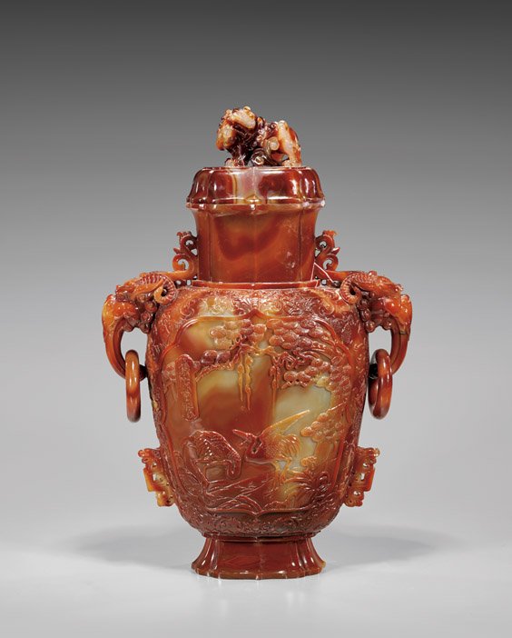 MASSIVE CARVED CARNELIAN AGATE COVERED URN: 瑪瑙雕松鶴紋獸鈕環耳蓋瓶 MASSIVE CARVED CARNELIAN AGATE COVERED URN Magnificent and of an unusually large size, finely carved Ch
