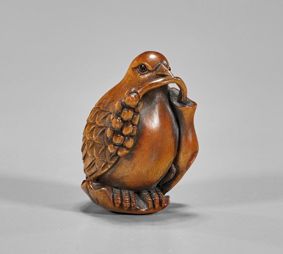 Carved Wood Netsuke: Bird: Carved Wood Netsuke: Bird Carved wood netsuke; of a bird with a branch of berries in its mouth; inlaid eyes; signed