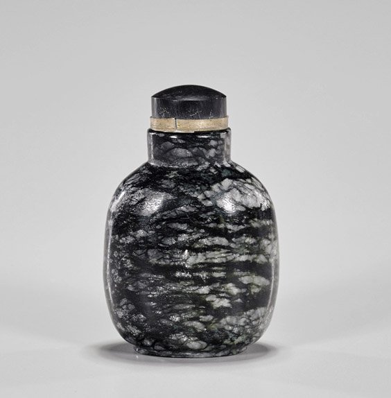 Carved Snowflake Obsidian Snuff Bottle: Carved Snowflake Obsidian Snuff BottleWell hollowed, carved snowflake obsidian snuff bottle; of rounded square form with raised foot, matching stopper (no spoon); H: 2 1/2"