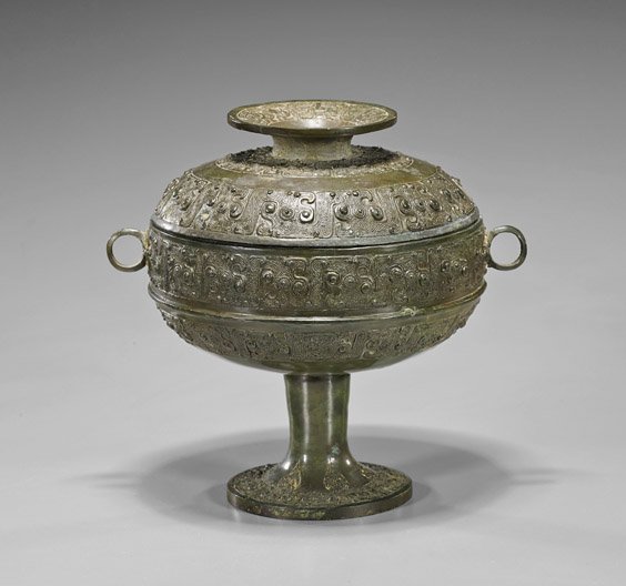 Antique Chinese Bronze Food Vessel (Dòu): Antique Chinese Bronze Food Vessel (Dòu) Antique Chinese Eastern Zhou-style bronze covered food vessel (dòu); of spherical form on a central high foot and two loop handles, decorated with multiple b