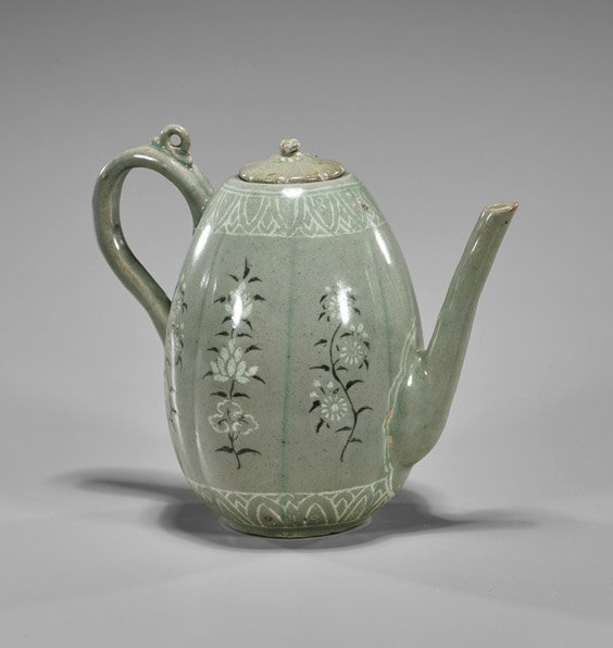 Korean Celadon Glazed Porcelain Ewer: Korean Celadon Glazed Porcelain Ewer Korean celadon glazed porcelain ewer; of egg-form with tall handle and spout; floral designs within each rib (minor degradation; misfired and flaws); H: 6 1/2”