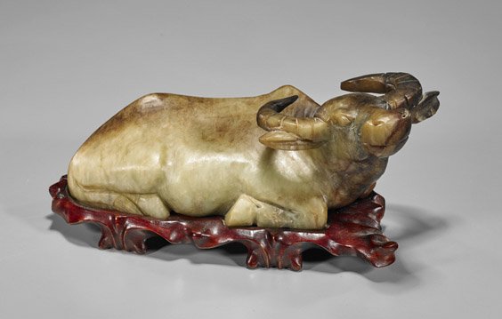 Chinese Carved Soapstone Water Buffalo: Chinese Carved Soapstone Water Buffalo Chinese soapstone carving of a water buffalo; recumbent with head raised and ears alert (wear and chipping); L: 10"; wood stand
