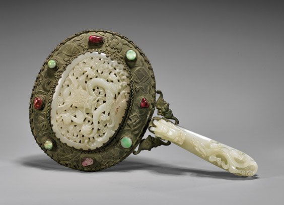 ANTIQUE JADE-SET HAND MIRROR: ANTIQUE JADE-SET HAND MIRRORAntique Chinese silvered repoussé hand mirror, set with two dragon-motif antique white jades: finely openwork carved belt buckle; and a large pierced carved oval plaque; f