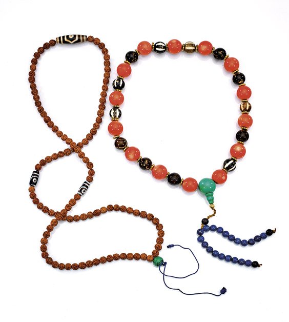 TWO BUDDHIST PRAYER BEAD NECKLACES: TWO BUDDHIST PRAYER BEAD NECKLACES Two Buddhist prayer bead necklaces: long strand comprised of small seed pit beads, with one large and two smaller ovoid dzi agate beads, the other of larger round be