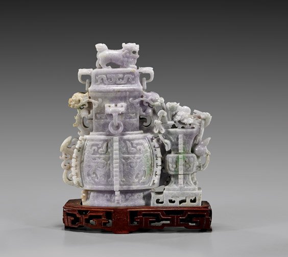 LAVENDER JADEITE DOUBLE-VASE GROUP: LAVENDER JADEITE DOUBLE-VASE GROUP Large Chinese jadeite double-vase group, each with notched flanges and interlocking archaistic panels; the larger vessel with matching cover surmounted with a lion, 