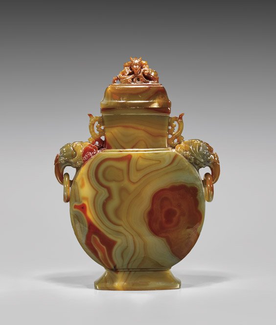 LARGE CARNELIAN AGATE COVERED URN: LARGE CARNELIAN AGATE COVERED URN Large Chinese carved carnelian agate covered urn; of flattened form with circular body, a finely carved qilin-headed handle pending a loose ring to either shoulder, t