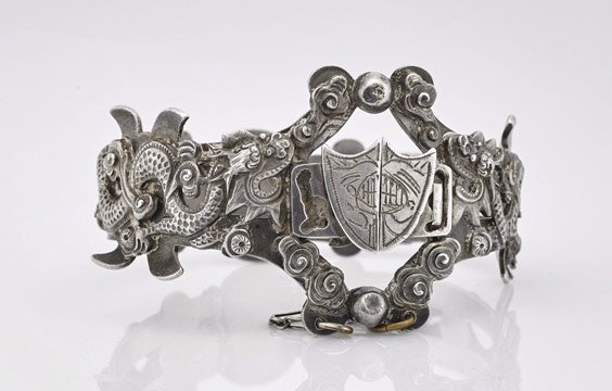 Old Chinese Silver Repoussé Bracelet: Old Chinese Silver Repoussé Bracelet Old Chinese silver repoussé bracelet; of two sinuous dragons contesting the flaming pearl, opening at the front with a heraldic shield center; seal marks (typica