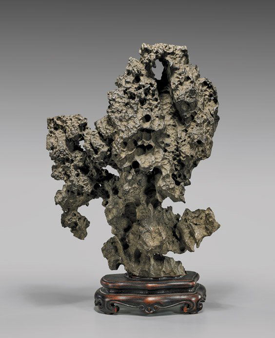 CHINESE LINGBI SCHOLAR'S ROCK: CHINESE LINGBI SCHOLAR'S ROCKChinese lingbi stone scholar's rock; the dark grey jagged natural form reminiscent of a cliffside overlooking a rushing river, with many crevices and openings throughout;