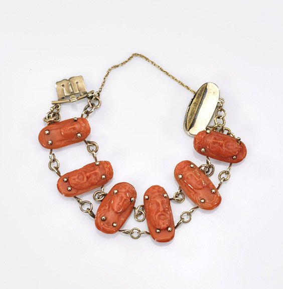 Childs' Carved Coral Bracelet: Childs' Carved Coral Bracelet Child's carved coral bracelet; six oblong beads with alternating European profiles of a man and woman, set on gilt chain (wear); D: 3"