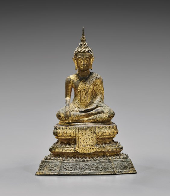 ANTIQUE THAI GILT BRONZE BUDDHA: ANTIQUE THAI GILT BRONZE BUDDHA Antique Thai gilt bronze Buddha; in partial-lotus position, with hands in bhumisparsa ('earth-touching') mudra, draped in ornate robes, with a tall spire to hair; seate