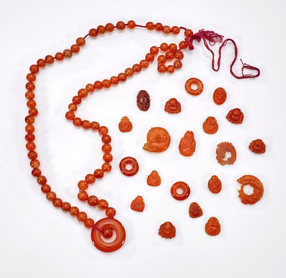 Chinese Carved Carnelian Beads: Chinese Carved Carnelian Beads Collection of Chinese carved carnelian beads: a long necklace with uniformed circular beads with bi pendant; twelve small Budai plaques; four bi pendants; figural; two d