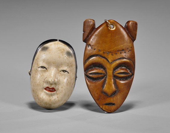 Two Wood & Ceramic Netsuke: Masks: Two Wood & Ceramic Netsuke: Masks Carved wood mask of elongated form with "ears" high on the head and stylized features to the face; together with small rounded ceramic female face, the features paint