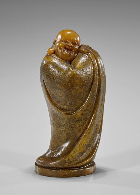 Chinese Carved Soapstone Budai: Chinese Carved Soapstone Budai Chinese carved soapstone Budai; standing with robes wrapped tightly around, a small bat under his chin; H: 7 1/4"