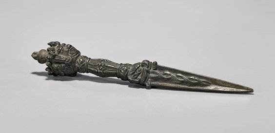 OLD TIBETAN PHURBA DAGGER: OLD TIBETAN PHURBA DAGGEROld Tibetan bronze or iron, Buddhist ritual phurba dagger; the triangular pointed blade with intertwined decoration, the handle terminating in three faces; L: 8 1/2"