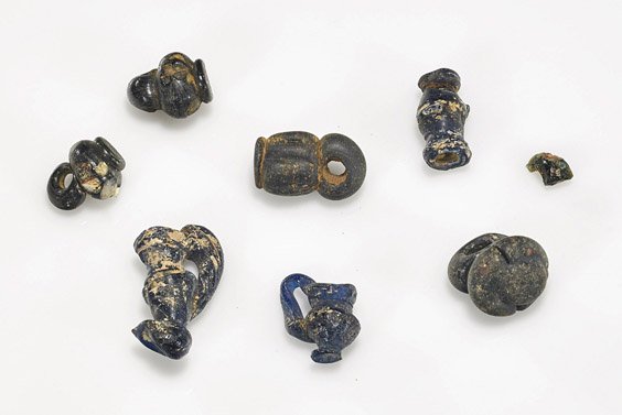 Seven Roman-Egyptian Glass Votives: Seven Roman-Egyptian Glass Votives Seven miniature ancient Roman-Egyptian mould-blown glass votives; in the form of various shaped vessels (some losses and earth deposits); L: 1" (largest)