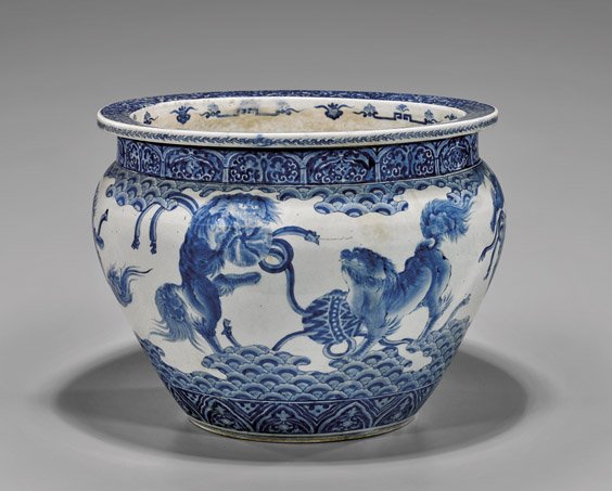 ANTIQUE JAPANESE BLUE & WHITE JARDINIÈRE: ANTIQUE JAPANESE BLUE & WHITE JARDINIÈRE Large and antique, Japanese blue and white porcelain jardinière; with continuous design of playful Shi-shi with patterned balls, above a stylized wave border