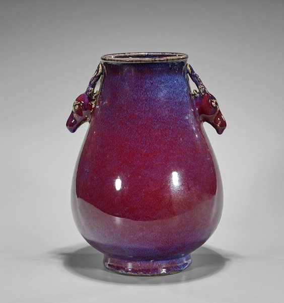 Chinese Ox Blood Glazed Porcelain Vase: Chinese Ox Blood Glazed Porcelain Vase Chinese ox blood flambé glazed porcelain vase; of rounded hu form with deer head handles; H: 11 3/4"