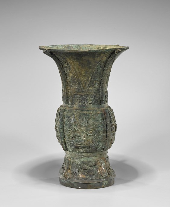 Western Zhou-Style Bronze Zun Vessel: Chinese Western Zhou-style bronze zun wine vessel; with a bulging center and flanges to the cardinal sides, taotie mask and archaistic designs;; H: 13 1/2"