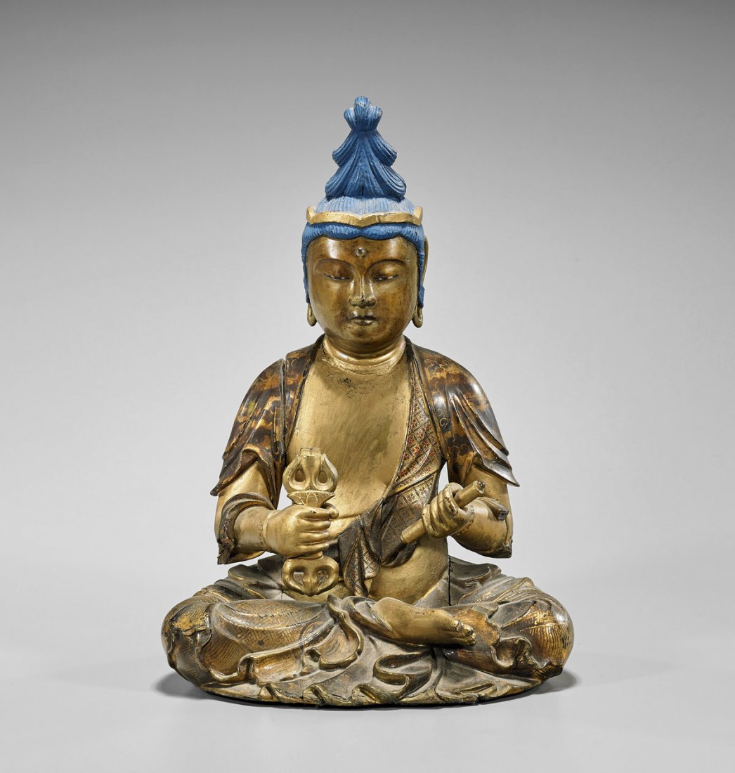 Antique Chinese Gilt Wood Seated Figure: Antique Chinese gilt and lacquered wood Buddhist figure; seated in lotus position, holding a dorje in one hand and a scroll in the other; with elaborate blue updo and well-detailed meander and foliate