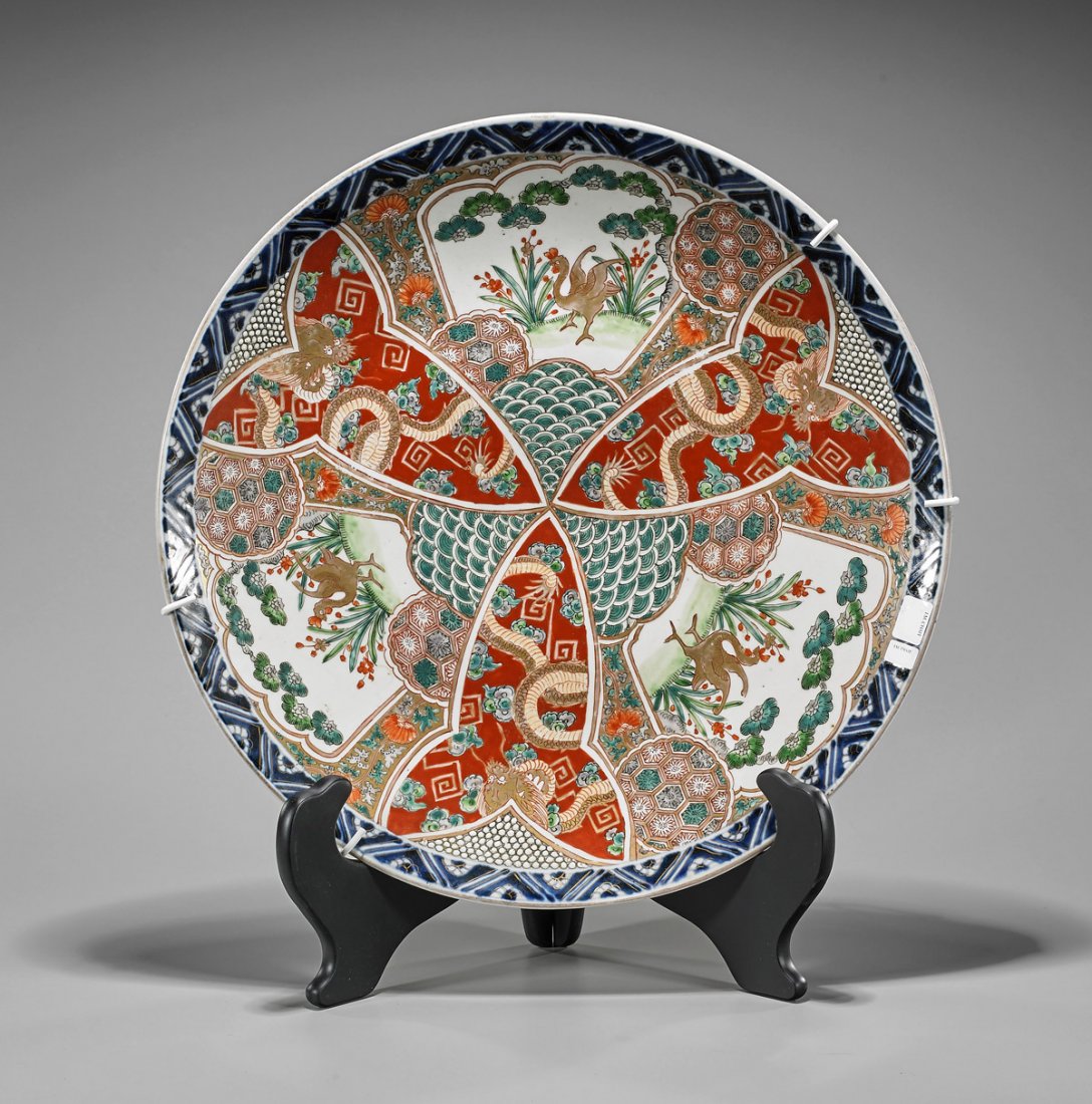 Antique Japanese Imari Porcelain Charger: Large and antique Japanese Imari porcelain charger; with gilt dragon, rooster and floral designs in overlapping scalloped reserves; D: 18"; with plate stand
